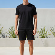 Person wearing black shorts with a white background
