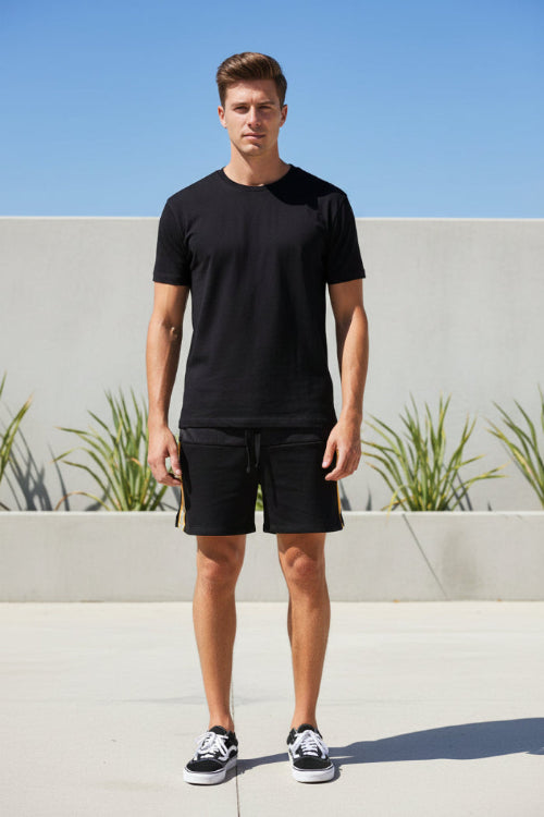Person wearing black shorts with a white background