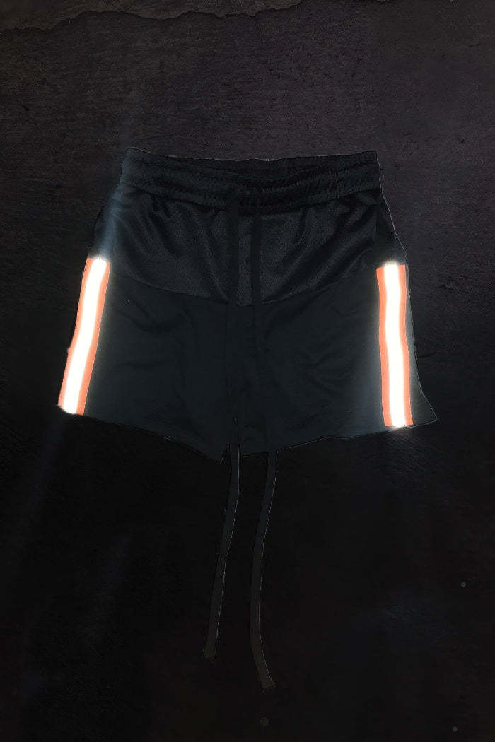 Black shorts with reflective stripes on a dark background
