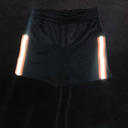 Black shorts with reflective stripes on a dark background