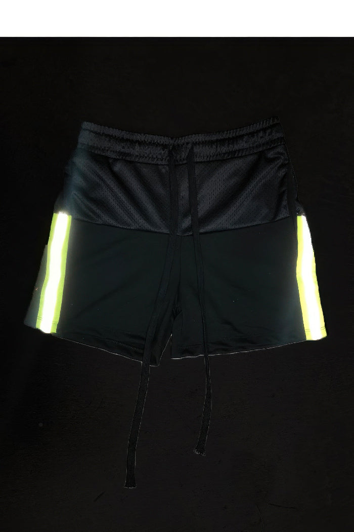 Black shorts with reflective yellow stripes on a black background