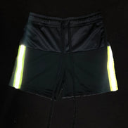 Black shorts with reflective yellow stripes on a black background