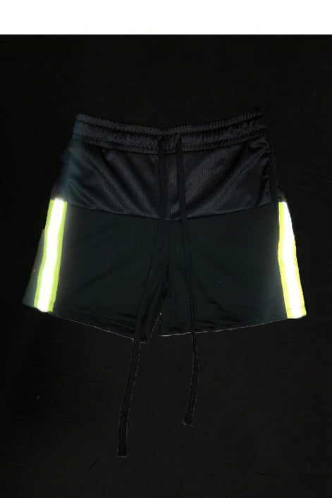 Black shorts with reflective yellow stripes on a black background