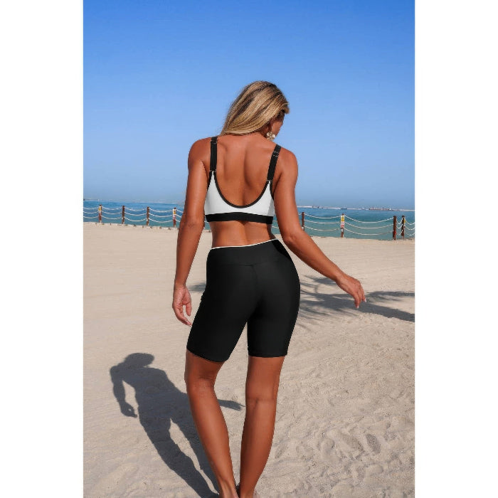 Woman in athletic wear standing on a beach with ocean view