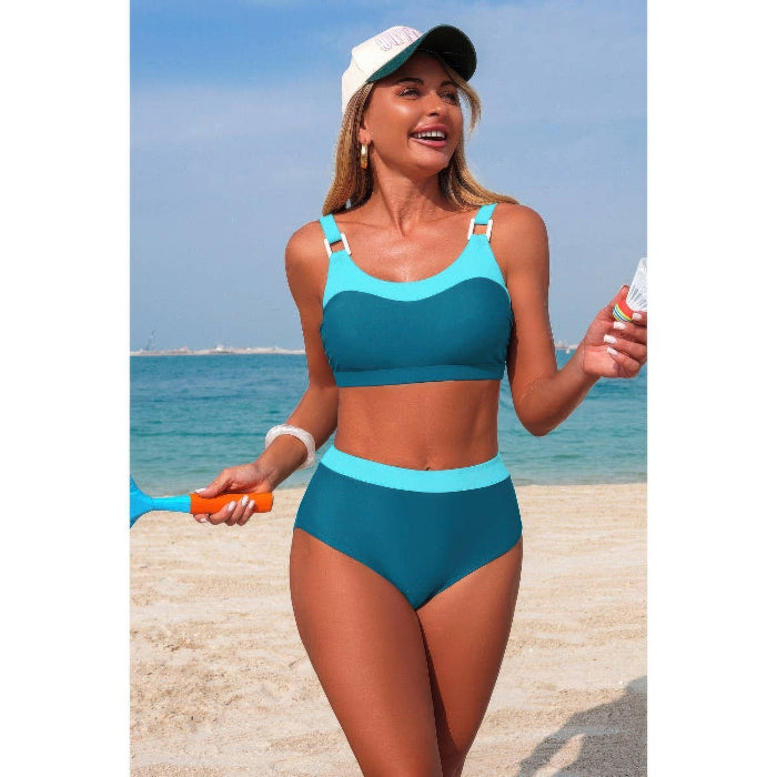 Woman in teal bikini with white visor on a beach
