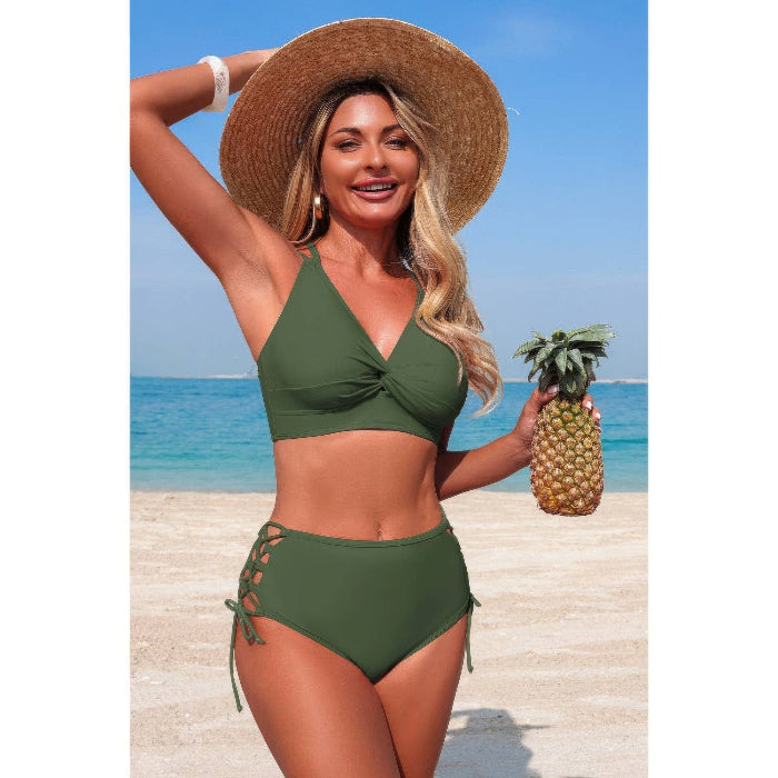 Woman in green bikini holding a pineapple on a beach