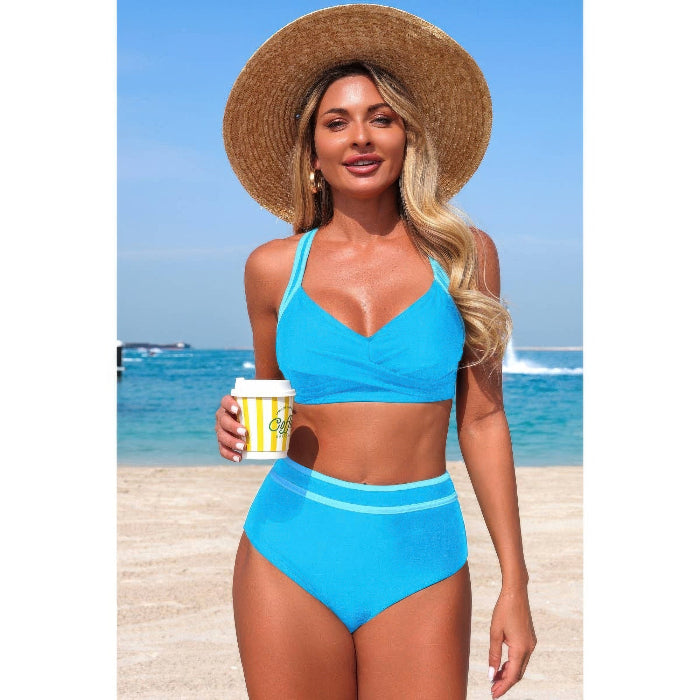 Woman in a blue bikini holding a coffee cup on a beach