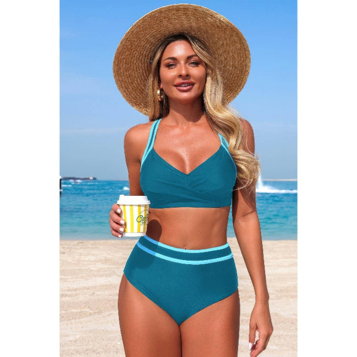 Woman in teal bikini holding a coffee cup on a beach