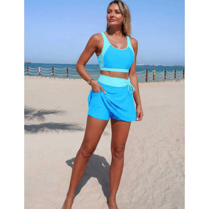 Woman in blue athletic wear standing on a beach with ocean view