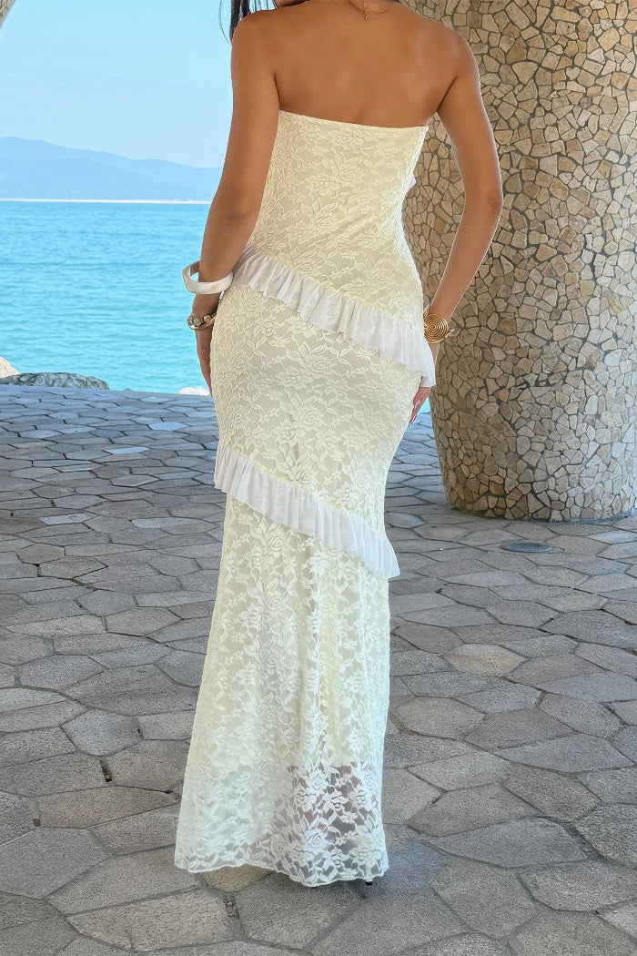 Woman in a white lace dress standing on a stone path with a scenic background