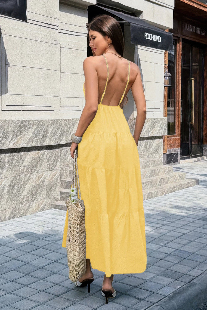 Woman in a yellow dress walking on a street with a building in the background