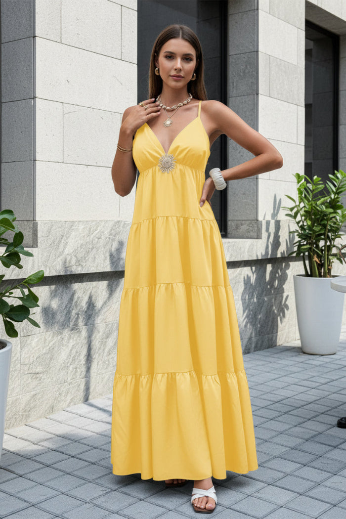 Woman in a yellow dress sitting outdoors on a stone patio.