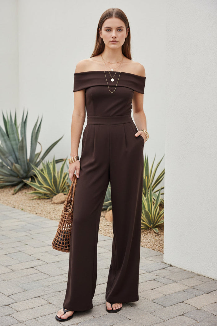 Woman wearing a brown off-shoulder dress standing outdoors.
