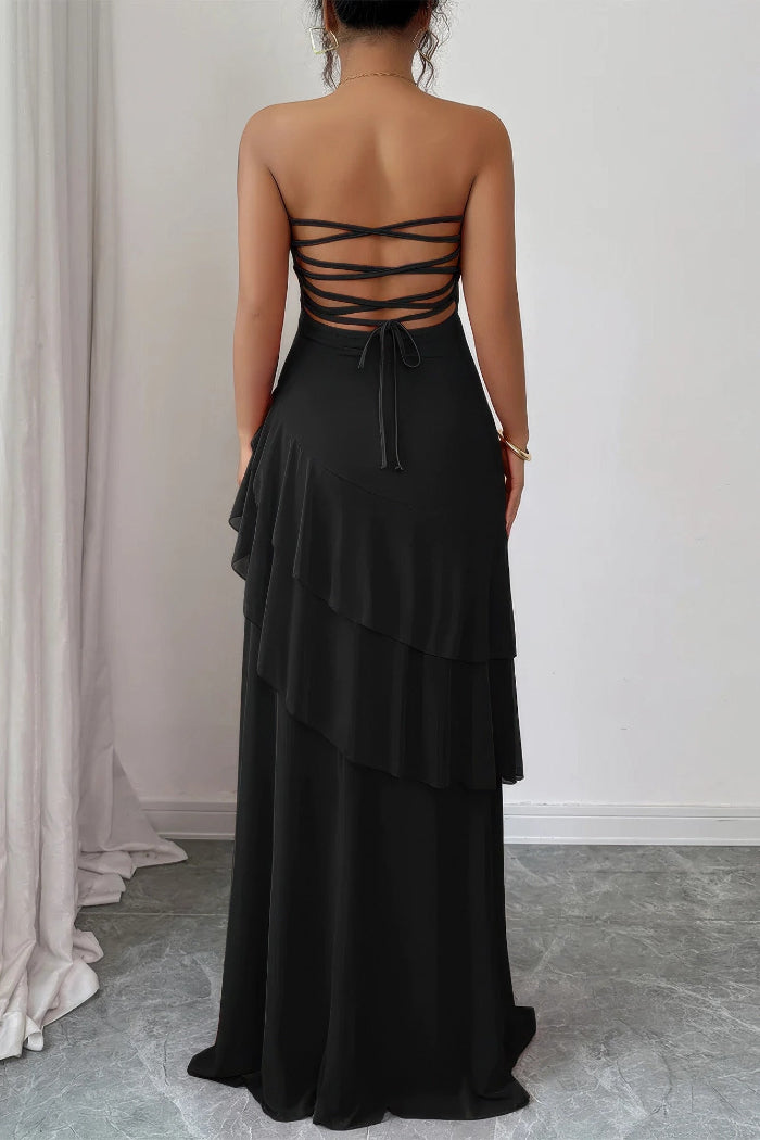 Black strapless gown with layered skirt on a neutral background