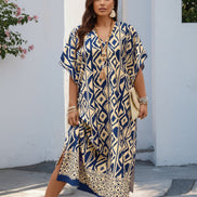 Woman wearing a blue and yellow patterned dress against a white wall.