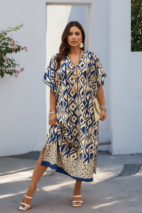 Woman wearing a blue and yellow patterned dress against a white wall.