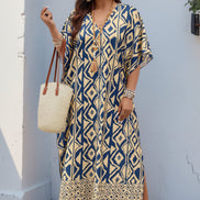 A woman models a bohemian-style kaftan dress featuring a navy blue and beige geometric ikat pattern. 