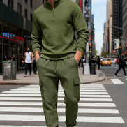 A man wearing an olive green textured quarter-zip pullover and matching cargo jogger pants 