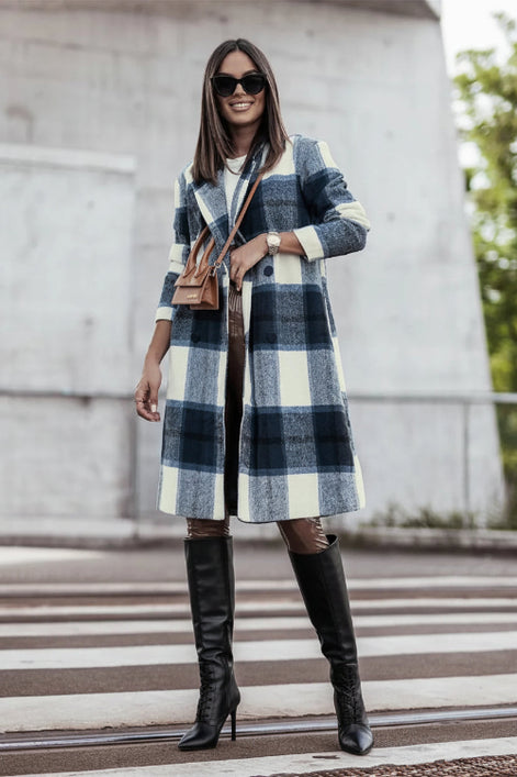 Woman wearing a plaid coat and brown boots on a city street.