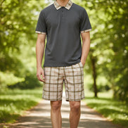 Gray polo shirt with plaid collar and beige plaid shorts on a white background