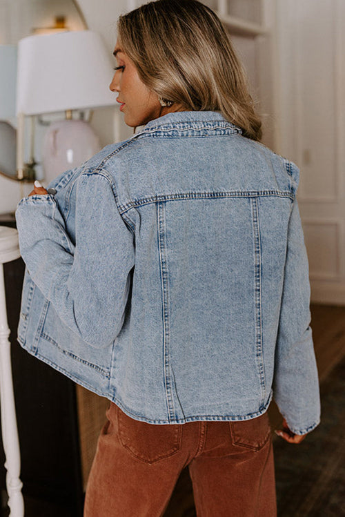 Person wearing a light blue denim jacket indoors