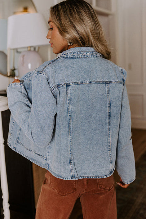 Person wearing a light blue denim jacket indoors