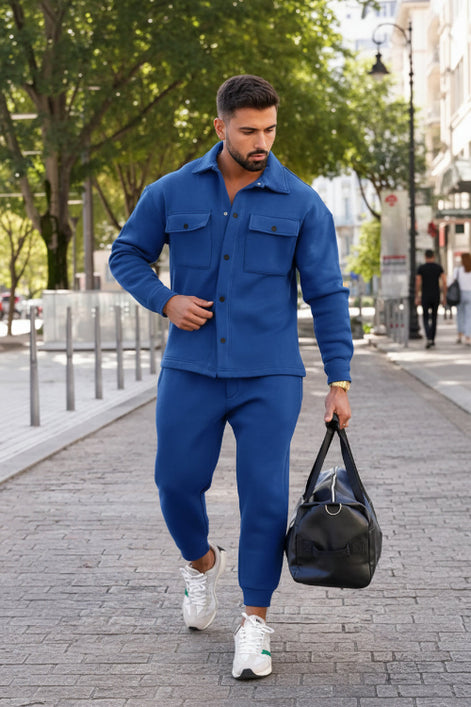 A man wearing a matching royal blue fleece jacket and jogger pants set, 