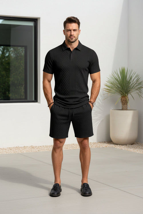 A man wearing a black short-sleeve polo shirt and matching black shorts 
