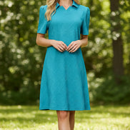 Woman wearing a teal dress on a beige background
