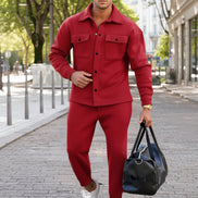 A man wearing a matching red button-up shirt and jogger pants set,