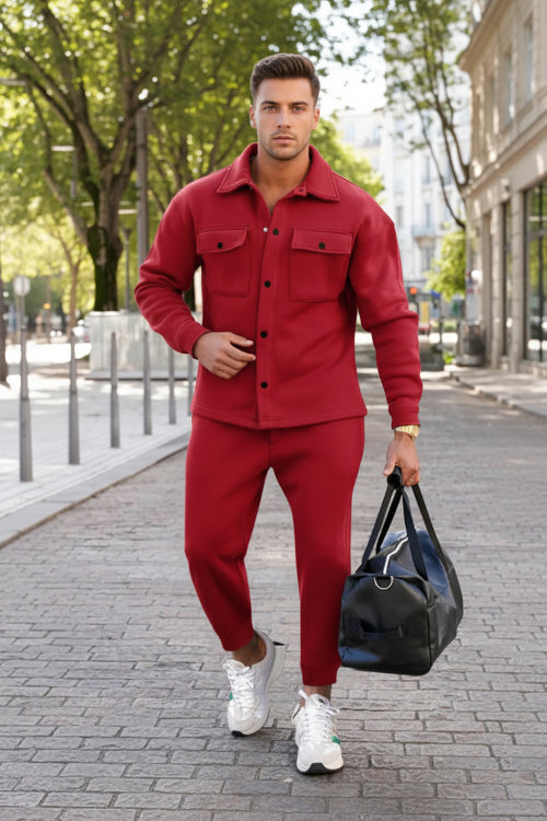 A man wearing a matching red button-up shirt and jogger pants set,