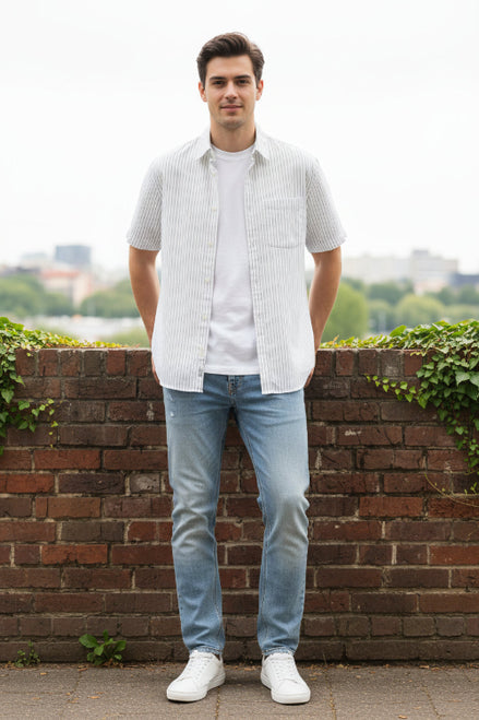 White short-sleeve shirt with thin black stripes on a hanger against a gray background
