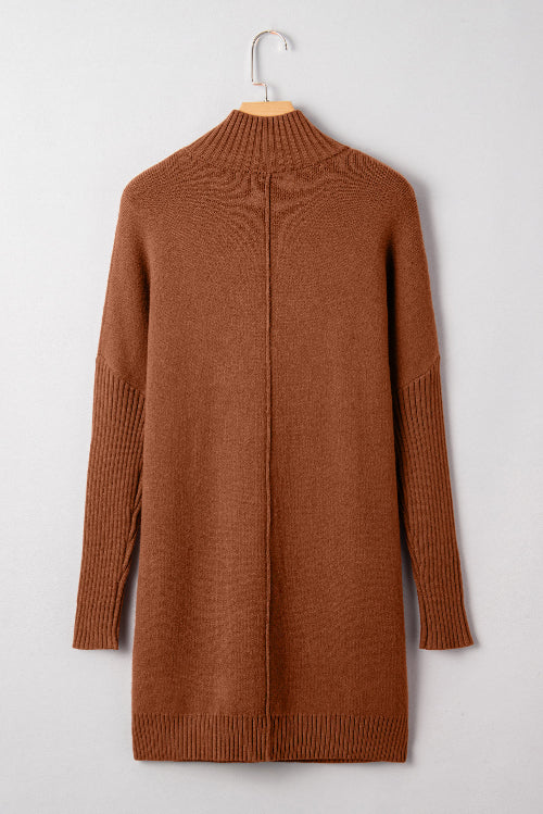 Brown sweater dress on a hanger against a white background