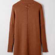 Brown sweater dress on a hanger against a white background