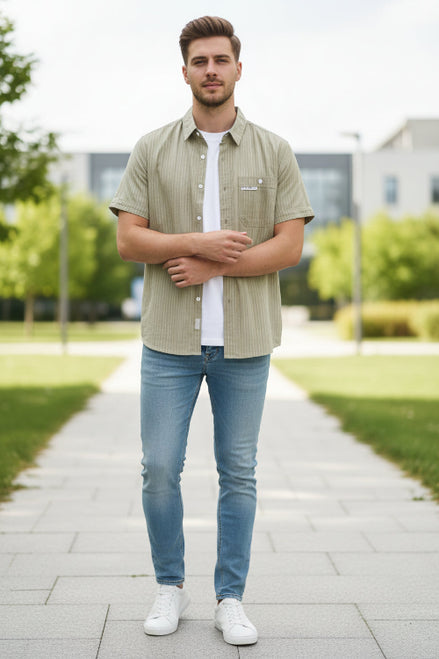 Beige striped shirt on a hanger against a gray background