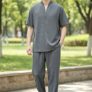 Person wearing a gray outfit with a plain background