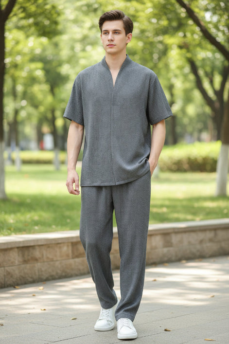 Person wearing a gray outfit with a plain background
