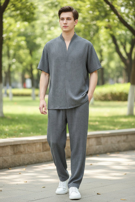 Person wearing a gray outfit with a plain background