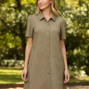 Woman wearing a patterned dress against a plain background