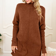 Woman wearing a brown sweater dress with a black hat indoors.