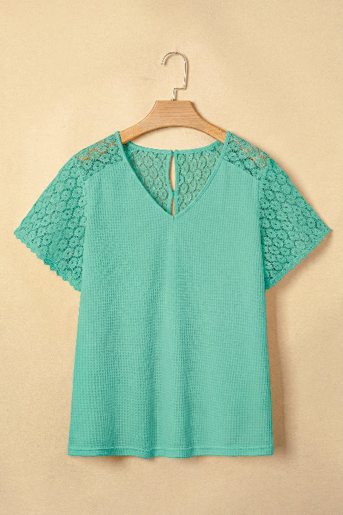 Green blouse with lace details on a beige background