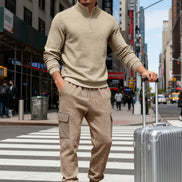 A man wearing a beige textured quarter-zip pullover and matching cargo jogger pants 