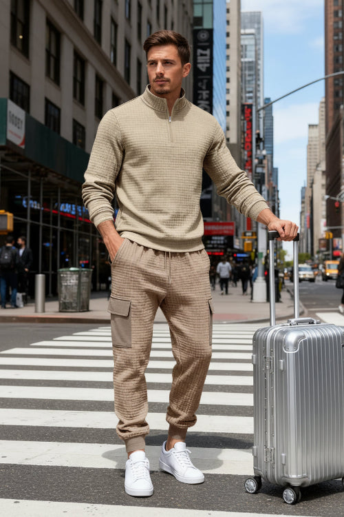 A man wearing a beige textured quarter-zip pullover and matching cargo jogger pants 
