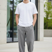 A person wearing gray ribbed corduroy pants with a white t-shirt and black-and-w
