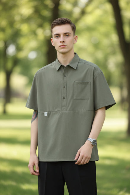 Person wearing a green short-sleeve shirt with a pocket on a white background