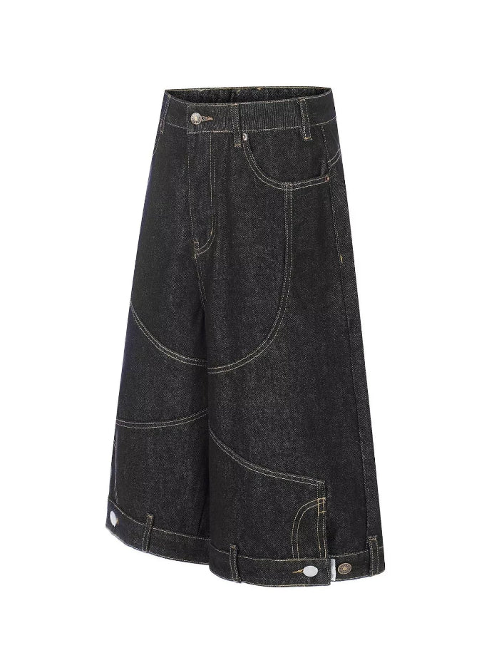 A pair of wide-leg denim shorts in a washed black or charcoal denim, styled with contrast light-colored stitching and button details on the hem, shown against a plain white background.