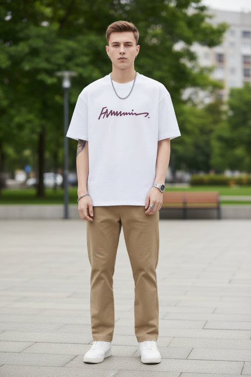 Person wearing a white t-shirt with a logo on a plain background