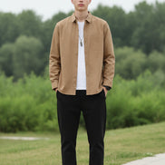 Brown button-up shirt worn by a person on a gray background