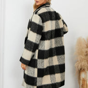 Woman wearing a black and white checkered coat against a white background