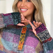 Woman wearing a colorful patchwork sweater with a blurred background
